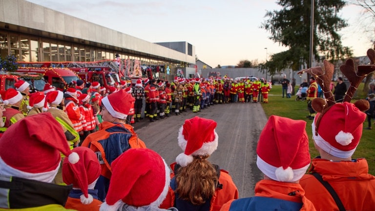 Viele Helfer im Rund - Ansprache des Feuerwehrkommandaten zum Weihnachtscorso der Rettungskräfte