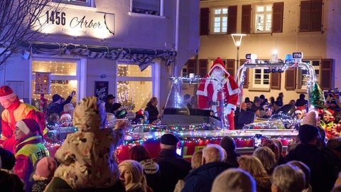 Der Weihnachtsmann auf einem geschmückten DLRG Boot - drum herum Schaulustige 