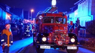 Ein altes Feuerwehrauto mit Drehleiter beim Weihnachtscorso der Rettungskräfte in Rheinfelden