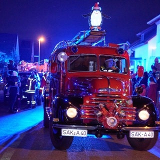 Ein altes Feuerwehrauto mit Drehleiter beim Weihnachtscorso der Rettungskräfte in Rheinfelden