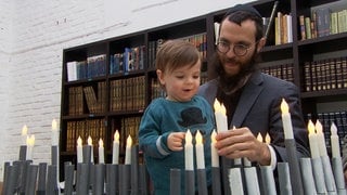 Rabbiner Jakov Gitler steckt mit seinem Sohn Kerzen-Leuchter für einen Autokorso zusammen