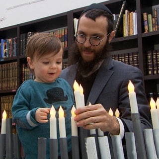 Rabbiner Jakov Gitler steckt mit seinem Sohn Kerzen-Leuchter für einen Autokorso zusammen