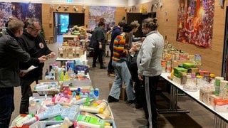 Auf den Tischen sammeln sich die Spenden für die Weihnachtstüten. 