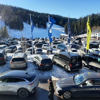 Am Loipenzentrum Notschrei parken viele Auto im Schnee.