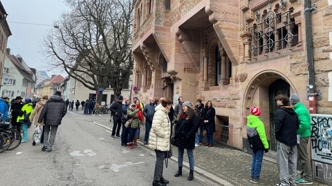 Menschen protestieren in Freiburg gegen die Freistellung von Domkapellmeister Boris Böhmann. 