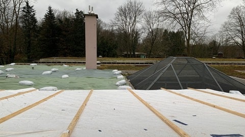 Ein provisorisches Dach mit Säcken und weißen Planen. Rettungskräfte haben den Tieren übergangsweise einen Ersatz für das verkohlte Dach gebaut. Bei dem Brand im Freiburger Tierheim wurde es zerstört.