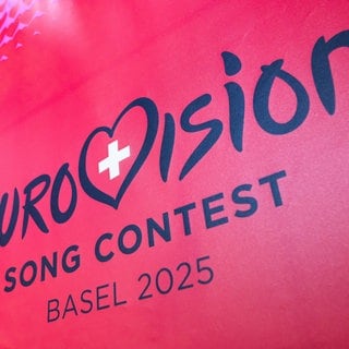 Das Logo des Eurovision Song Contests (ESC) 2025: in dunkler Schrift auf pinkem Hintergrund - samt einem Herz mit dem Schweizer Kreuz.