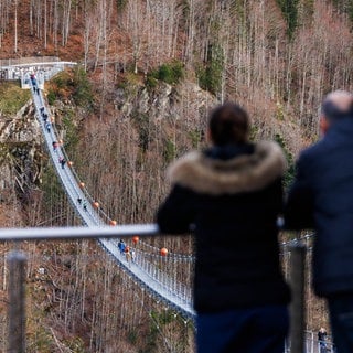 Menschen stehen auf der "Blackforestline", einer Hängebrücke in Todtnau. In Rottweil soll nun ein ähnliches Tourismusprojekt starten.  