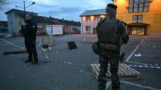 Ein Polizist und ein Soldat stehen nach einem tödlichen Angriff in Mulhouse im Elsass.