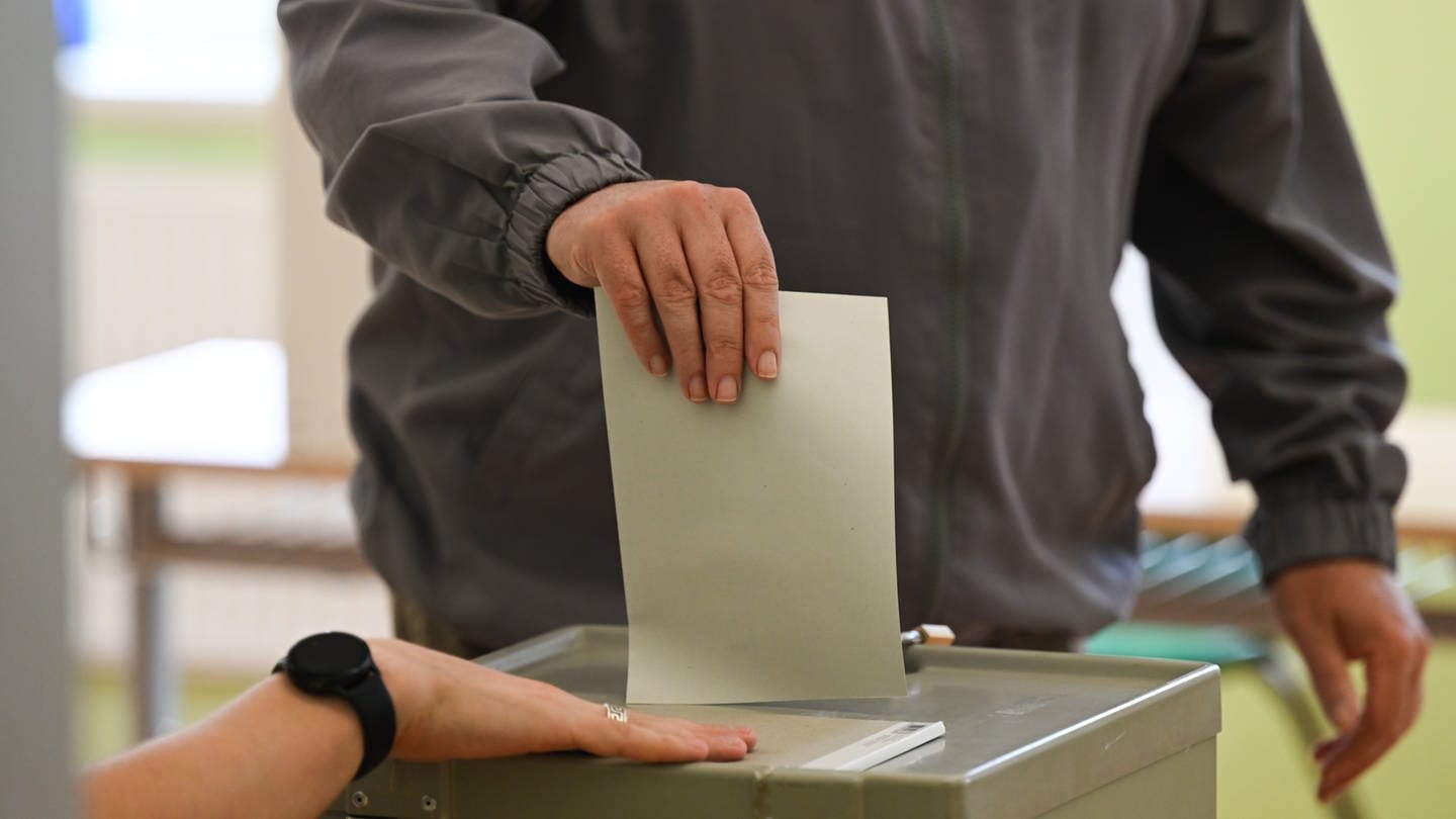 Ein Mann wirft seinen Stimmzettel in die Wahlurne.