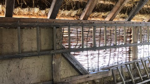 Die Wand wird zum Schutz vor Regen und Wind mit dem Stampflehm verputzt