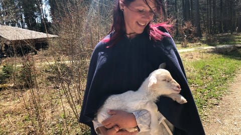 Tierpflegerin Mali mit einem kleinen Lämmchen auf dem Campus Galli