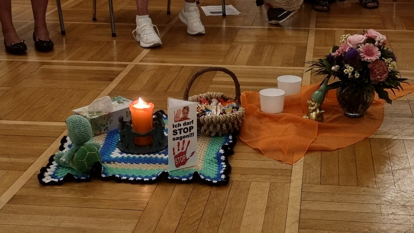 Eine Kerze steht in der Mitte eines Stuhlkreises bei einem Treffen der Elternselbsthilfegruppe für Eltern suchtkranker Kinder.