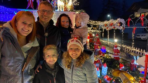 Familie Meißel vor ihrem leuchtenden Weihnachtshaus