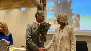 Gemeinderätin Annette Schmidt gratuliert dem Tübinger OB Boris Palmer mit einem Blumenstrauß zur 3. Amtszeit. 