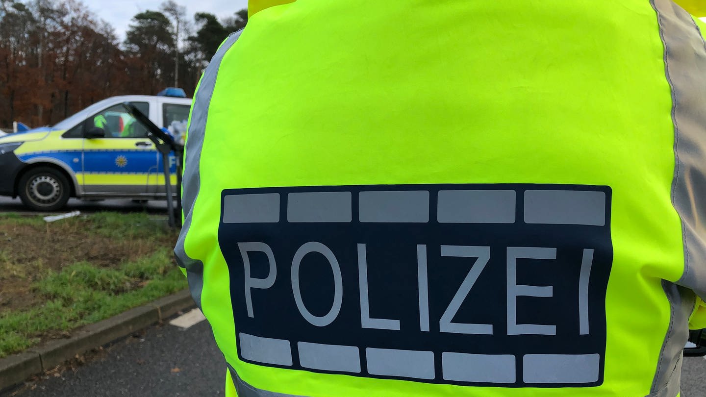 Zwei Tote auf dem Kniebis - Symbolbild: Polizei mit Leuchtweste und Streifenwagen