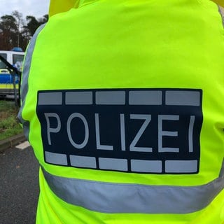 Zwei Tote auf dem Kniebis - Symbolbild: Polizei mit Leuchtweste und Streifenwagen 