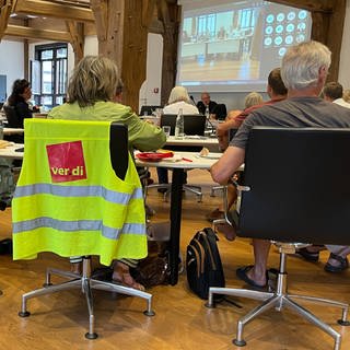 Eine Weste der Gewerkschaft ver.di hängt um einen Stuhl. Darauf sitzt eine Frau im Gemeinderat Tübingen. Sie ist Mitglied des Gemeinderats Tübingen.