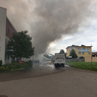 Aus der Lagerhalle einer Baufirma in Walddorfhäslach dringt dichter schwarzer Rauch.