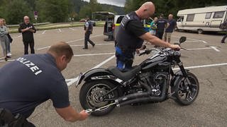 Zwei Polizisten untersuchen eine Harley Davidson