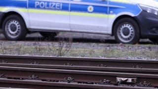 Ein Polizeiauto hinter Bahngleisen