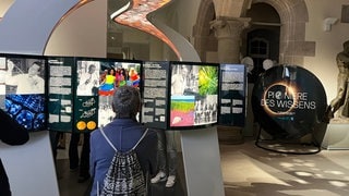 Eine Frau schaut sich die Ausstellung "Pioniere des Wissens" der Max-Planck-Gesellschaft an