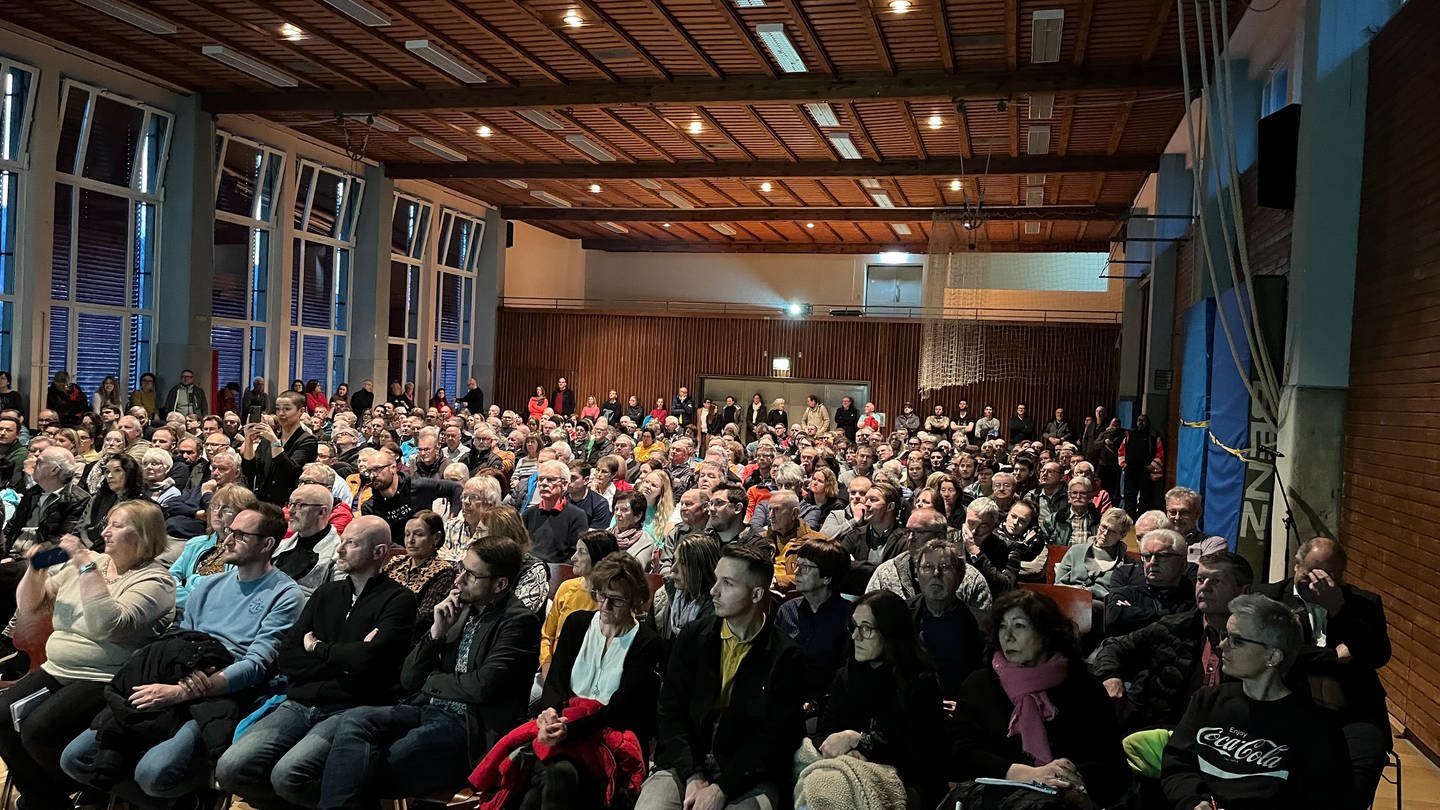 Rund 300 Menschen sitzen im bestuhlten Saal in der Turn- und Festhalle Albstadt-Laufen (Zollernalbkreis)