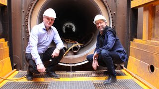 Oberbürgermeister Boris Palmer und swt-Geschäftsführer Ortwin Wiebecke in der Baugrube am Tunneleingang. Tübingen will 2030 klimaneutral sein und baut deshalb sein Fernwärmenetz aus.