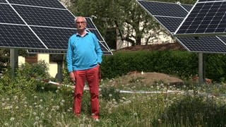 Willi Kemmler steht im Garten seiner Mietshäuser in Gomaringen (Kreis Tübingen). Um ihn herum ist ein Teil der Solaranlagen zu sehen, für die er seit fast einem Jahr keine Genehmigung bekommt.