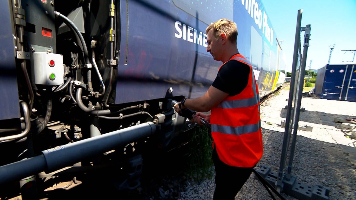Ein Mitarbeiter betankt einen der Wasserstoffzüge der Deutschen Bahn. Die Tankstelle gehört zum Kraftwerk am Hauptbahnhof in Tübingen