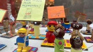 Man sieht Lego-Menschen. Zwei von ihnen halten Sprüche hoch. Auf einem steht: "Lieber mixen statt wegwerfen". Das Kunstprojekt soll Menschen für Lebensmittelverschwendung sensibilisieren.  