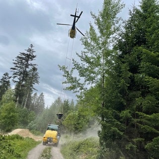 Ein Hubschrauber lässt sich mit Kalk vom Boden beladen