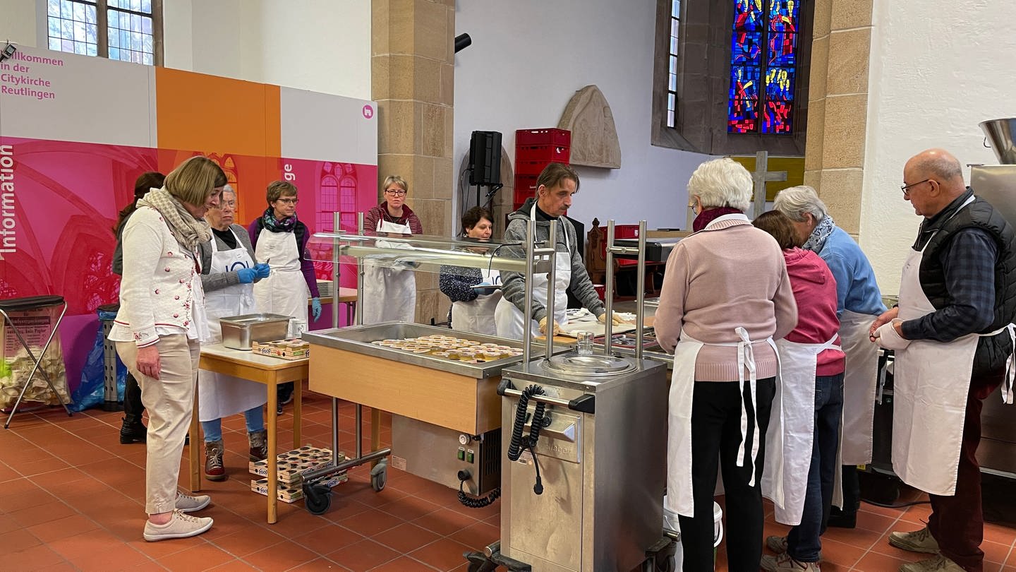 Helfer bereiten die Essen in der reutlinger Nikolaikirche vor
