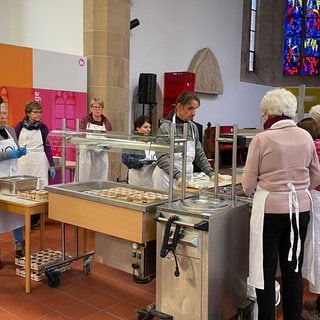 Helfer bereiten die Essen in der reutlinger Nikolaikirche vor