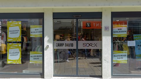 "Wir schließen" und "Räumungsverkauf" steht auf Schildern an einem Schaufenster in der Reutlinger Innenstadt.