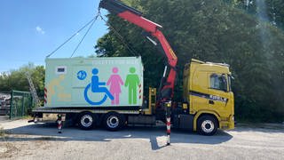 Ein Kranwagen hat die Reutlinger "Toilette für Alle" aufgeladen, um sie zu den Special Olympics nach Berlin zu bringen.