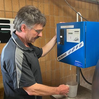 Thomas Schäfer zapft Milch am Milchautomaten