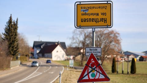 Unbekannte haben das Ortsschild von Harthausen umgedreht. Darunter ein durchgestrichenes Ampel-Verkehrsschild.