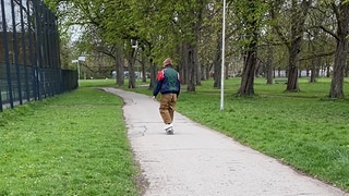 Mann mit Kapuze im Park unterwegs