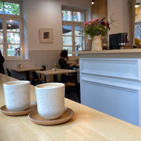 Zwei Tassen mit Kaffee stehen an einer Theke im Alten Waschaus in Tübingen. Betreiber von Cafés klagen, dass Besucher seit einiger Zeit die Tassen nicht zurückbringen.