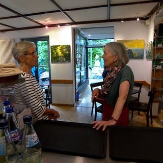 Barbara Haas und Christine Heppner im Gastraum vom Kaffeehäusle Reutlingen. Große helle Fenster lassen viel Licht herein. 