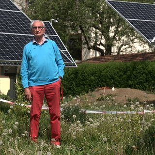 Willi Kemmler steht im Garten seiner Mietshäuser in Gomaringen (Kreis Tübingen). Um ihn herum ist ein Teil der Solaranlagen zu sehen, für die er nun - ein Jahr nach Baubeginn - eine Genehmigung bekommen hat.