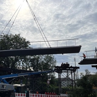 Das letzte Teilstück der Tübinger Radbrücke West wird von einem Krahn angehoben. 