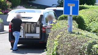 Gewalttat in Albstadt-Lautlingen: Fahrzeuge der Polizei und Polizisten stehen vor dem Tatort an dem am Sonntag drei Menschen gestorben sind.