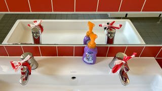 Die Wasserhähne in der Toilette in der KiTa am Park in Metzingen sind wegen dem möglicherweise immer noch verunreinigten trinkwasser mit rot-weißem Absperrband verknotet. Die KiTa am Park und das Pflegeheim Metzingen belasten Verunreinigungen in der Wasserversorgung.