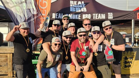 Die Mitglieder des Teams "Real Smoke BBQ" nach ihrem Sieg der Grillweltmeisterschaft zusammen auf einem Foto.