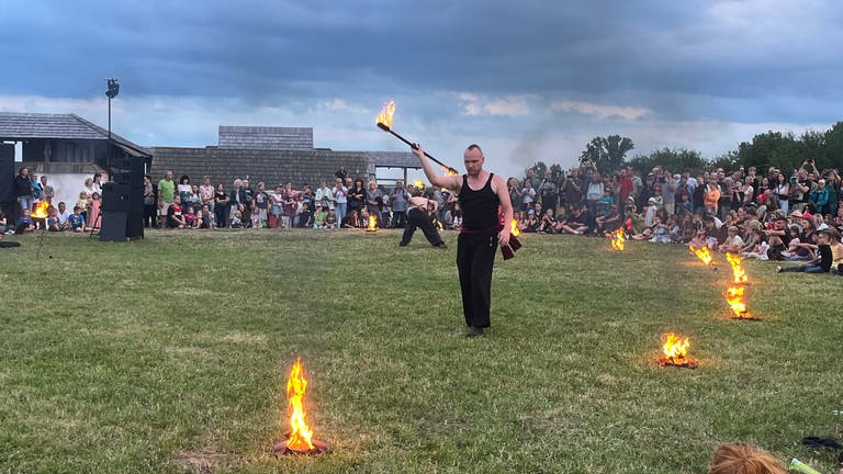 Lars Clef hat sich vorher gut aufgewärmt, damit er die Feuerbstäbe während der Show gut schwingen kann.