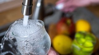 Tinkwasser läuft aus dem Wasserhahn in einer Küche in ein Glas. In Metzingen müssen Anwohner das Leitungswasser nicht mehr abkochen, wenn sie es trinken wollen. 