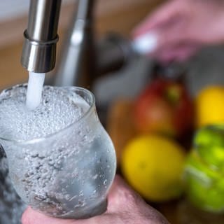 Tinkwasser läuft aus dem Wasserhahn in einer Küche in ein Glas. In Metzingen müssen Anwohner das Leitungswasser nicht mehr abkochen, wenn sie es trinken wollen. 