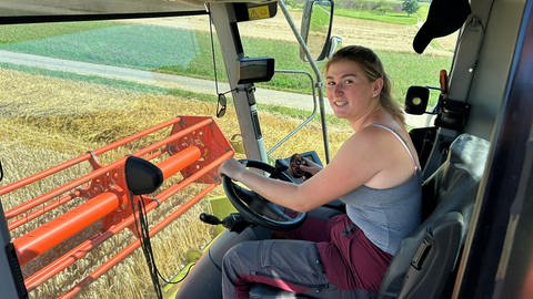 Leni Lutz sitzt am Steuer der Mähdresch-Maschine bei der Arbeit auf dem Feld. Sie ist die dritte Generation der Familie, die in das landwirtschaftliche Unternehmen einsteigt.